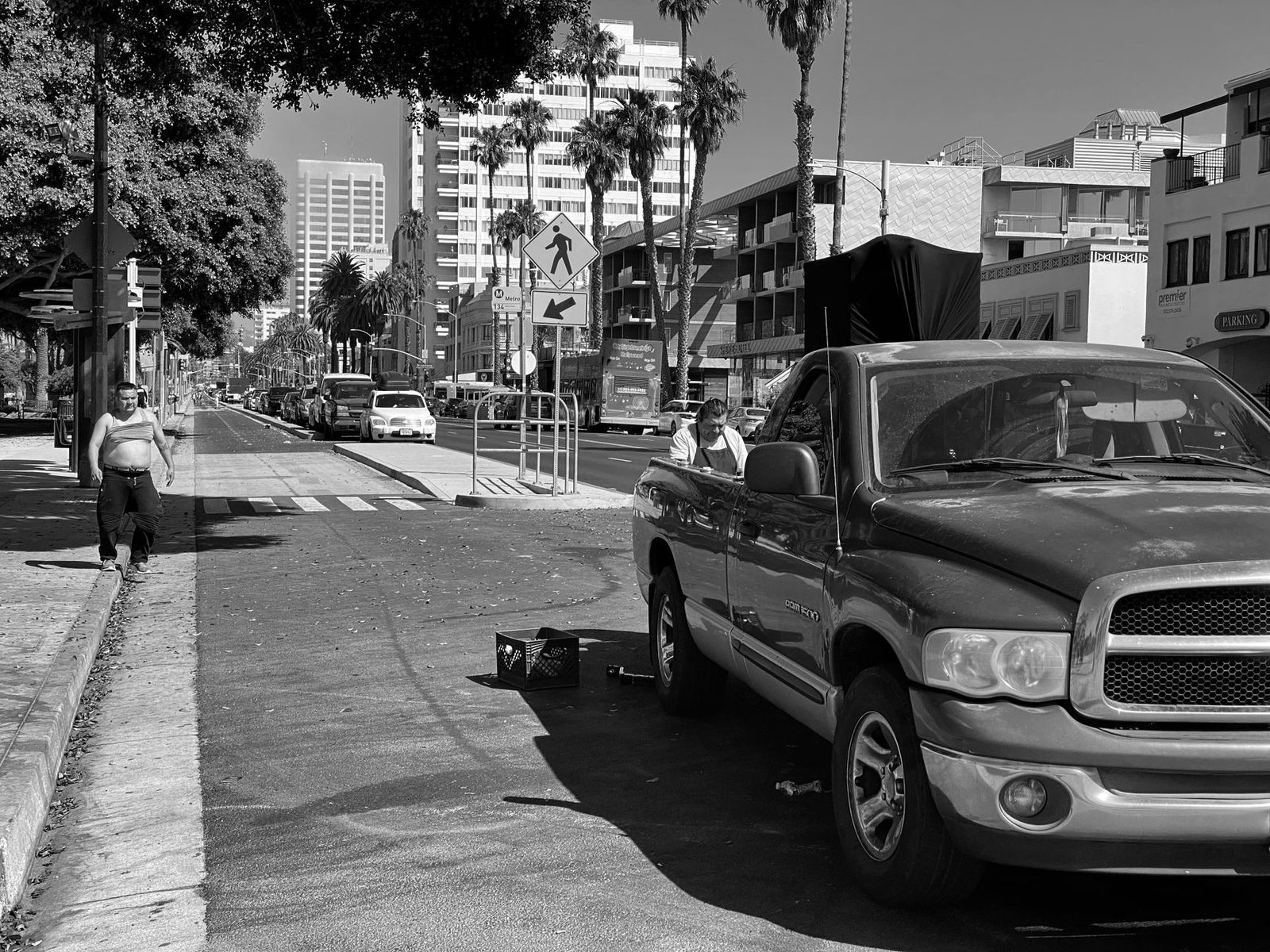 Black-and-white street scene in Santa Monica with pedestrians walking past a parked truck.