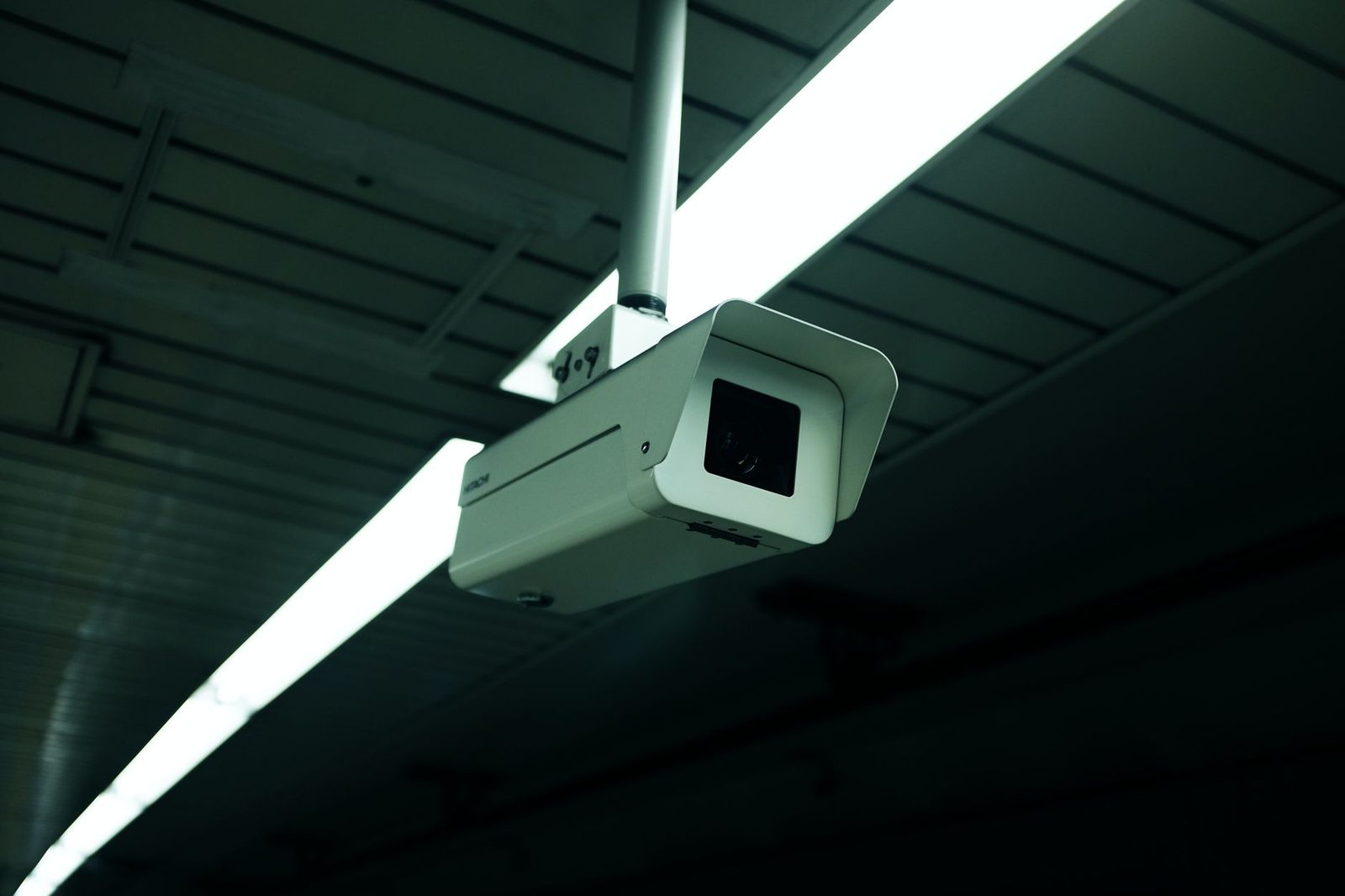 Close-up of a ceiling-mounted indoor security camera used for surveillance.