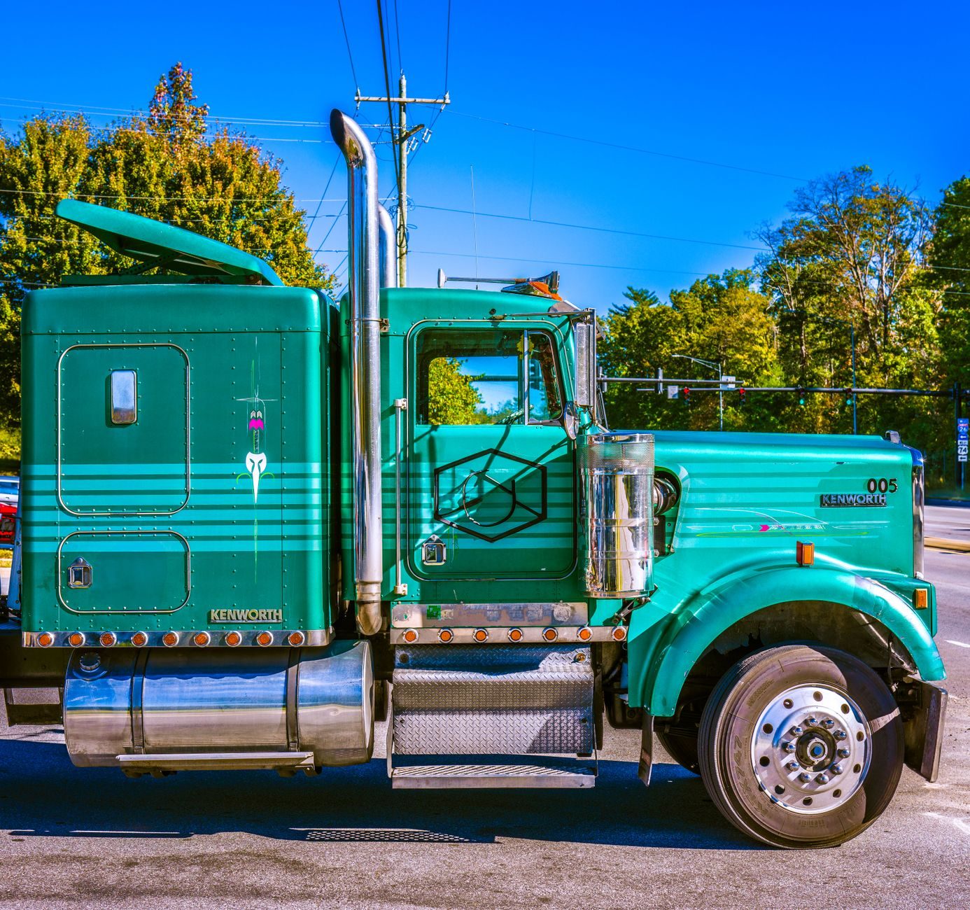 Camión Kenworth verde estacionado al aire libre en un día soleado.